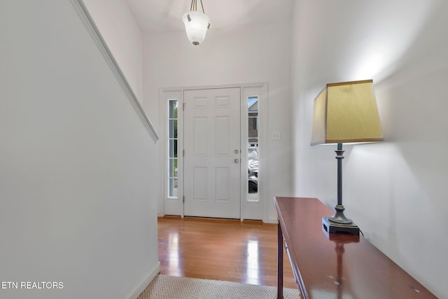 foyer entrance featuring light wood-style floors and baseboards