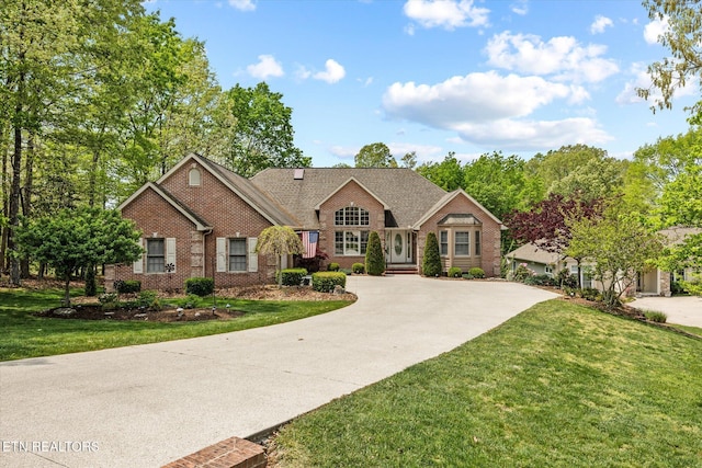 106 Mariners Dr, Fairfield Glade, TN 38558 - view of front facade featuring brick siding, curved driveway, and a front lawn