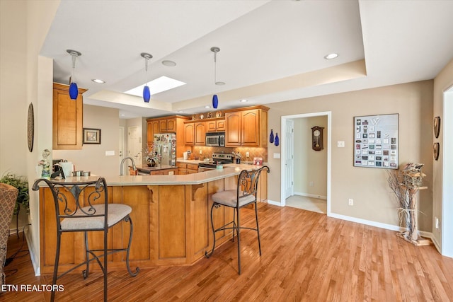 106 Mariners Dr, Fairfield Glade, TN 38558 - kitchen with a peninsula, a raised ceiling, appliances with stainless steel finishes, and a skylight