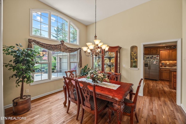 106 Mariners Dr, Fairfield Glade, TN 38558 - dining space with an inviting chandelier, baseboards, light wood finished floors, and a towering ceiling