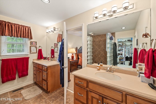 106 Mariners Dr, Fairfield Glade, TN 38558 - bathroom with visible vents, tile patterned flooring, vanity, a spacious closet, and a tile shower