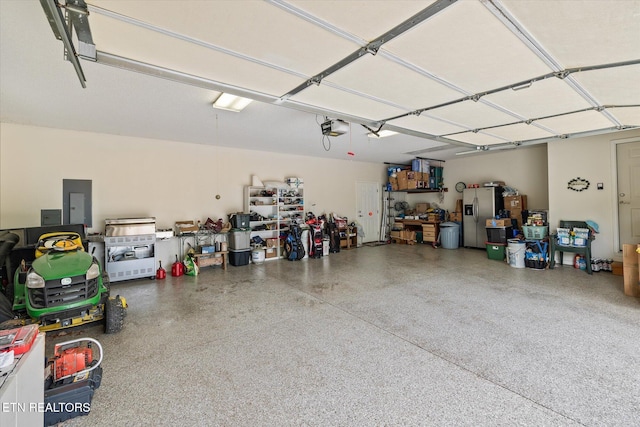106 Mariners Dr, Fairfield Glade, TN 38558 - garage with stainless steel refrigerator with ice dispenser, a garage door opener, and electric panel
