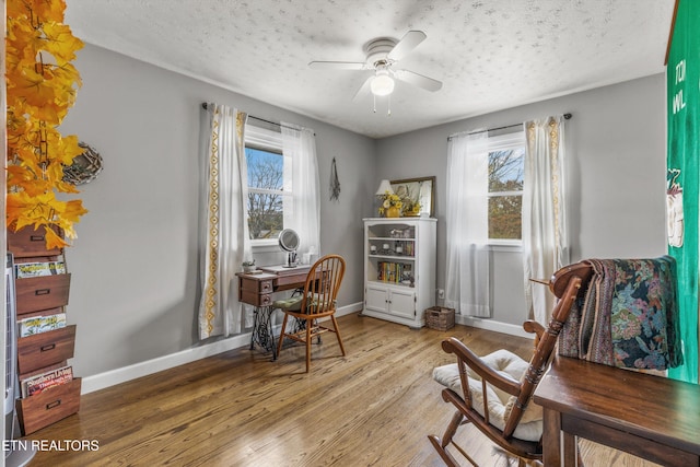 sitting room featuring a wealth of natural light, ceiling fan, wood finished floors, and baseboards