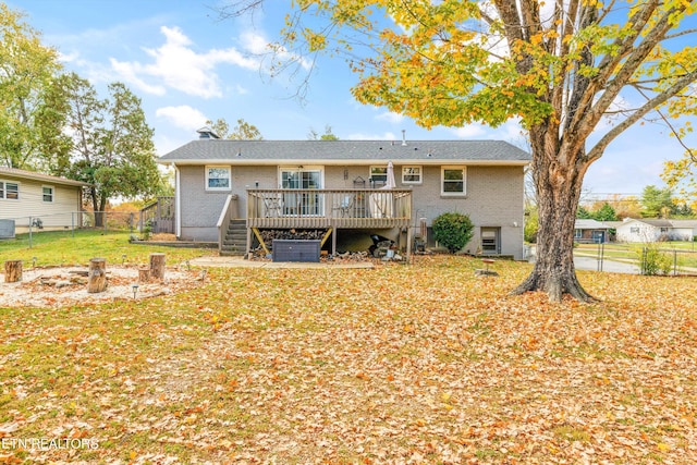 rear view of property featuring a yard, a wooden deck, fence private yard, and brick siding