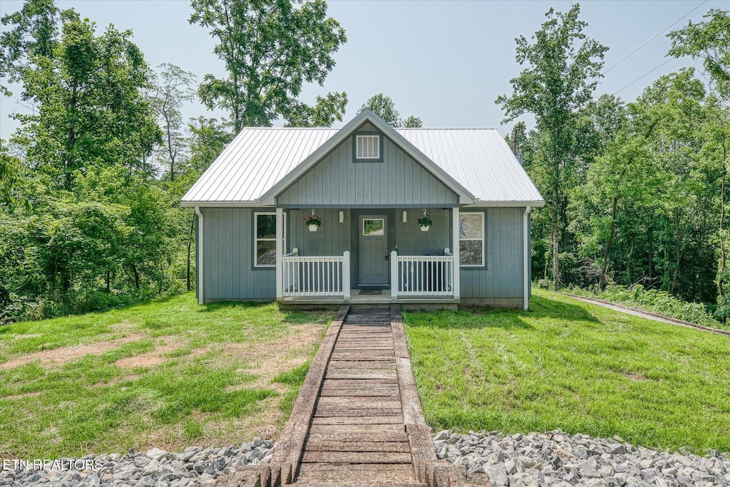 299 Shire Ln, Celina, TN 38551 - view of front of house featuring a porch, a front lawn, and metal roof