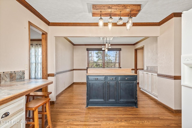 1441 Bunker Hill Rd, Cookeville, TN 38506 - kitchen with a textured ceiling, light wood-style flooring, crown molding, baseboards, and wooden counters