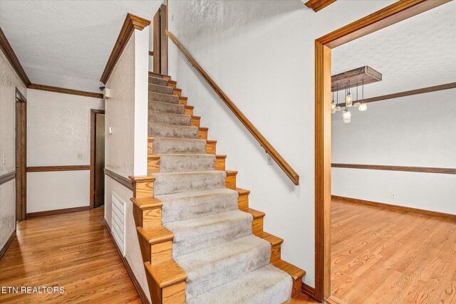 1441 Bunker Hill Rd, Cookeville, TN 38506 - stairs featuring baseboards, a textured ceiling, wood finished floors, and crown molding