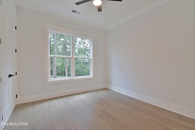 empty room featuring light wood-style flooring, ceiling fan, baseboards, and crown molding