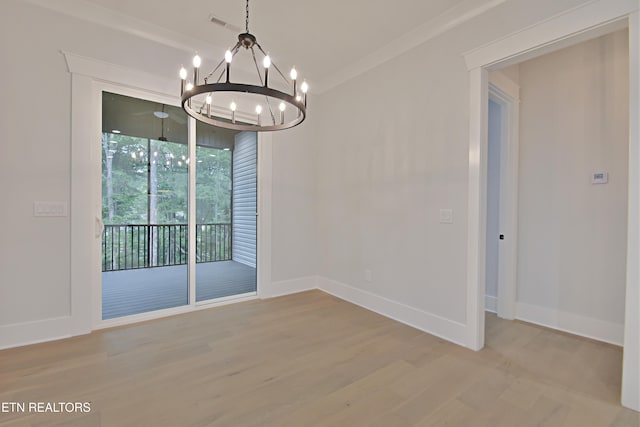 unfurnished dining area featuring a chandelier, wood finished floors, baseboards, and ornamental molding
