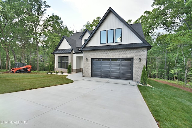 modern inspired farmhouse with brick siding, driveway, a front lawn, and a garage