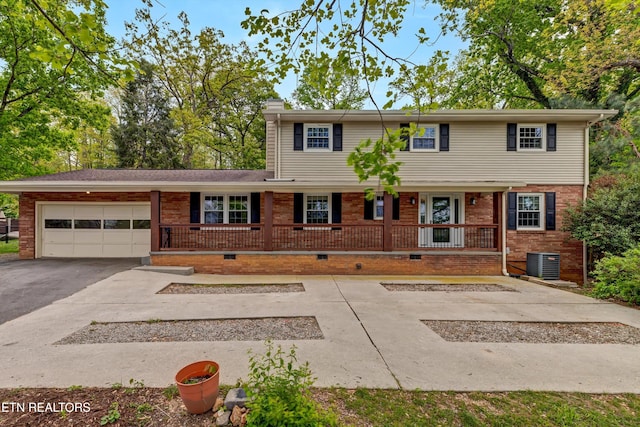 view of front of home featuring central AC unit, driveway, a porch, a garage, and crawl space