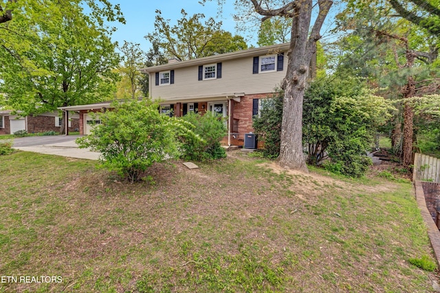 view of front facade featuring cooling unit, driveway, fence, brick siding, and an attached garage
