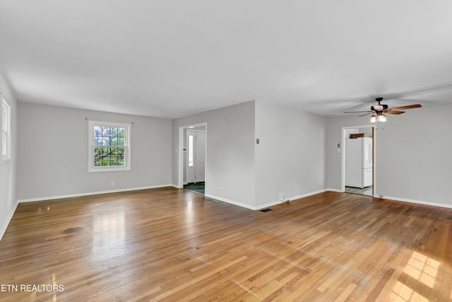 unfurnished living room with light wood finished floors, baseboards, and ceiling fan