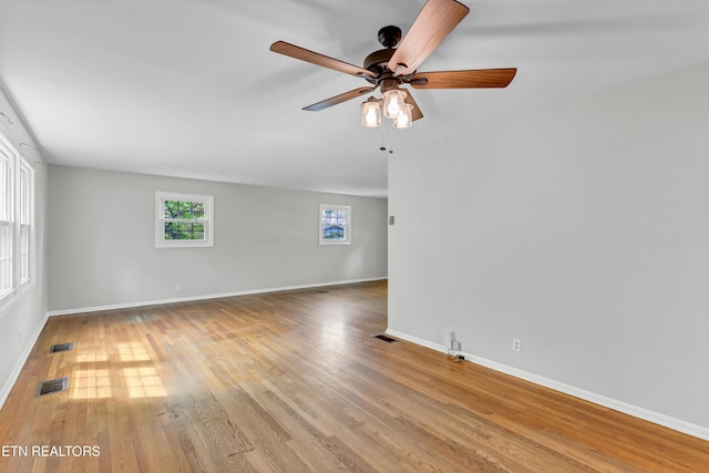 empty room with light wood-style floors, visible vents, baseboards, and ceiling fan