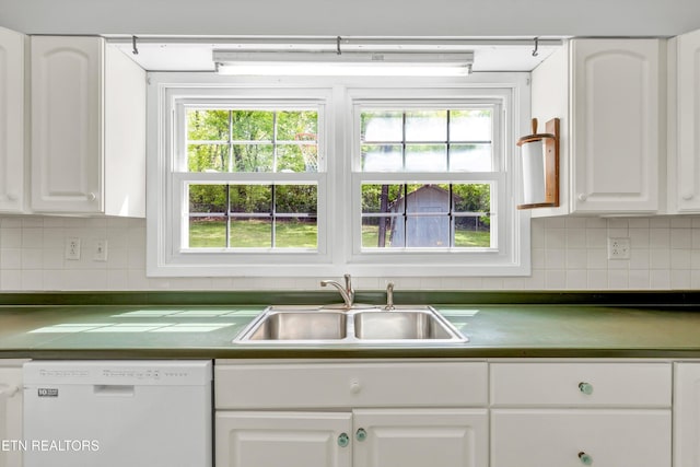 kitchen featuring decorative backsplash, white dishwasher, a sink, and white cabinetry