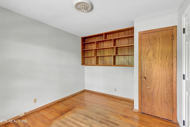 spare room featuring light wood-style flooring and baseboards