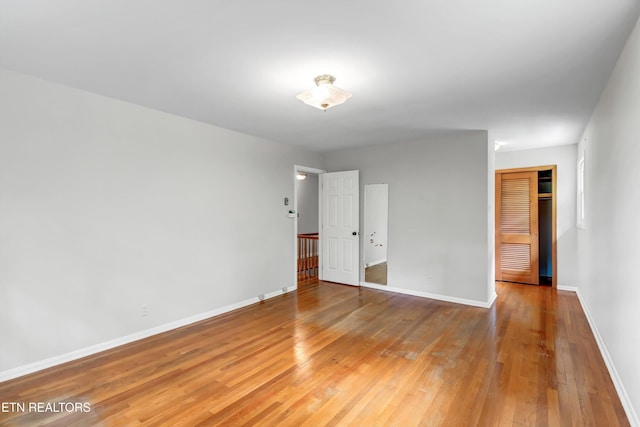 unfurnished room with baseboards and light wood-style flooring