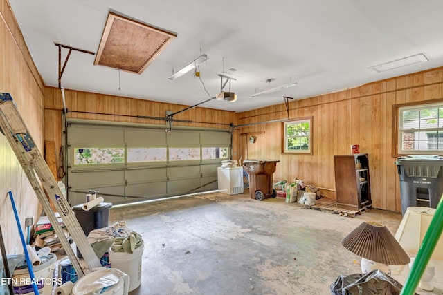 garage with wood walls and a garage door opener
