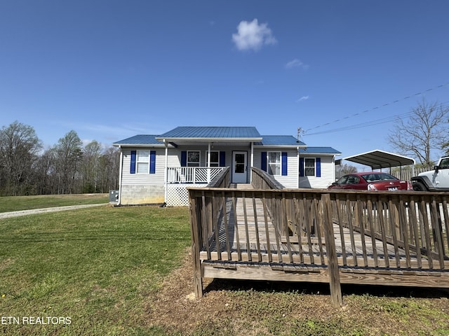 view of front of home with metal roof, a front yard, a carport, and a porch