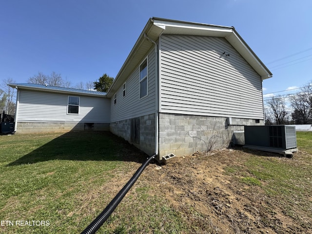 view of side of home with a lawn and central air condition unit