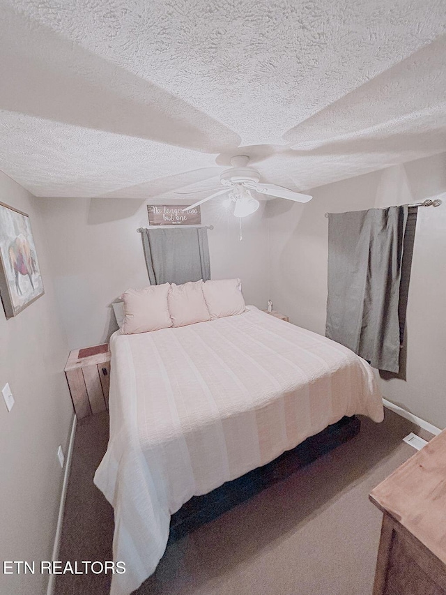 bedroom with a textured ceiling, baseboards, and ceiling fan