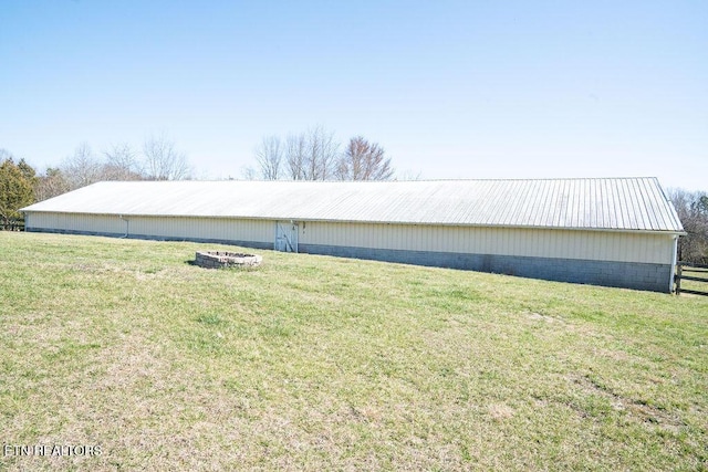 view of side of home featuring a lawn, an outdoor structure, fence, and an outbuilding