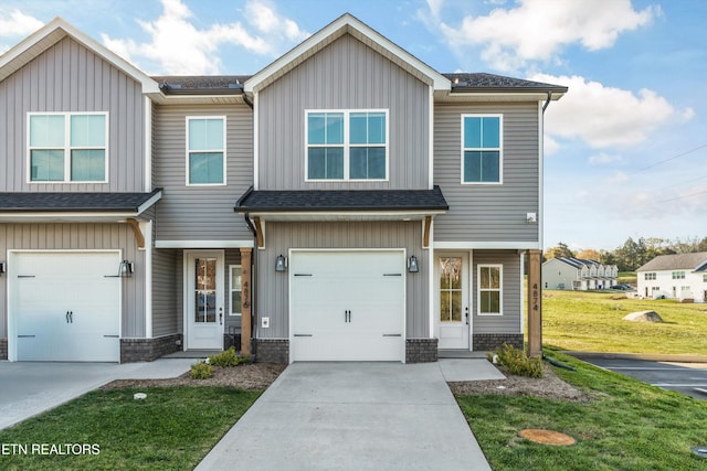 view of front of property with a garage, driveway, a shingled roof, and a front yard