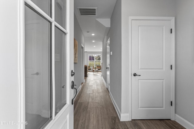 hallway with baseboards, visible vents, recessed lighting, and dark wood-style floors