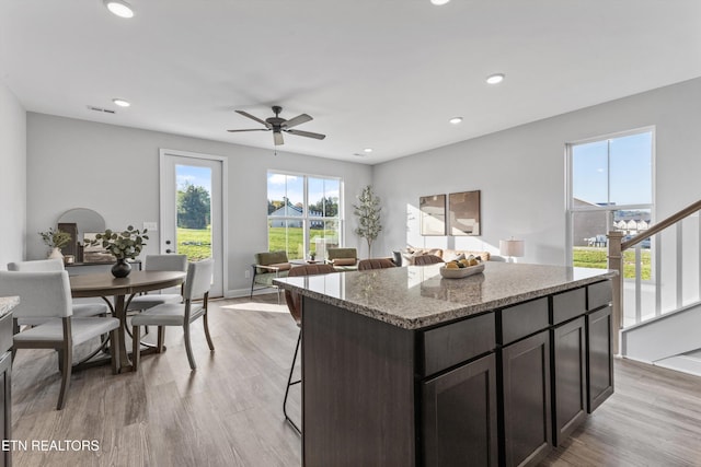 kitchen with recessed lighting, a ceiling fan, light wood-type flooring, and a kitchen island