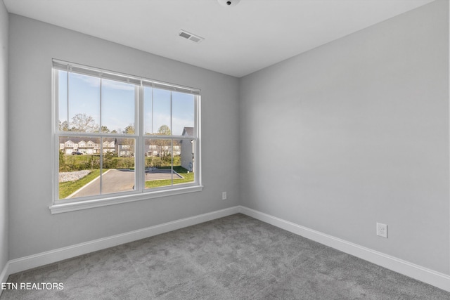 unfurnished room featuring baseboards, carpet flooring, visible vents, and plenty of natural light