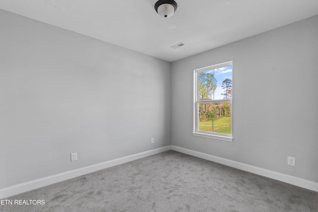 carpeted spare room featuring baseboards and visible vents