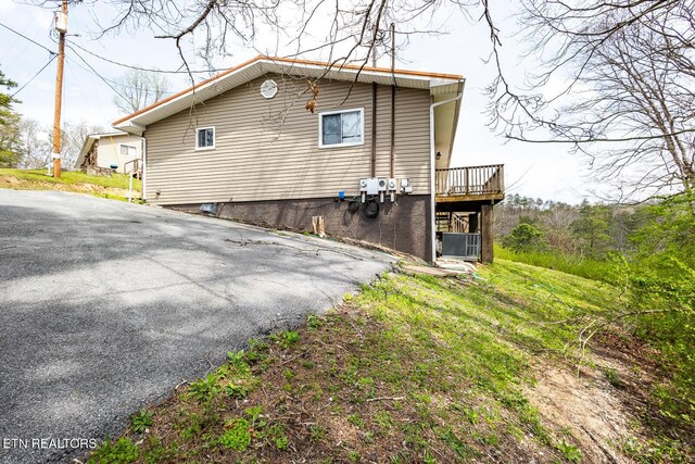 view of property exterior with a wooden deck