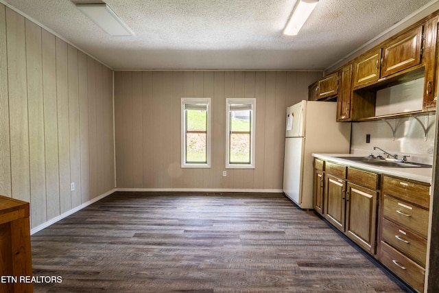 kitchen with a sink, a textured ceiling, dark wood-style floors, and freestanding refrigerator