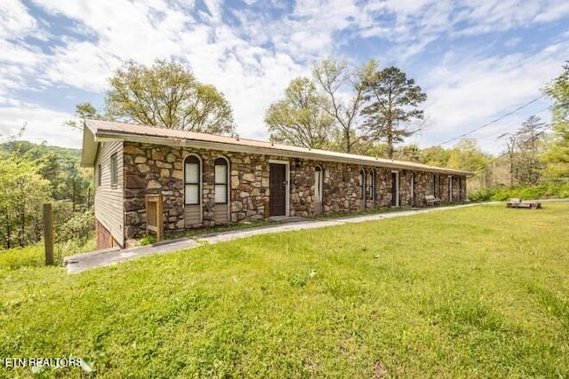 view of front of house with stone siding and a front yard