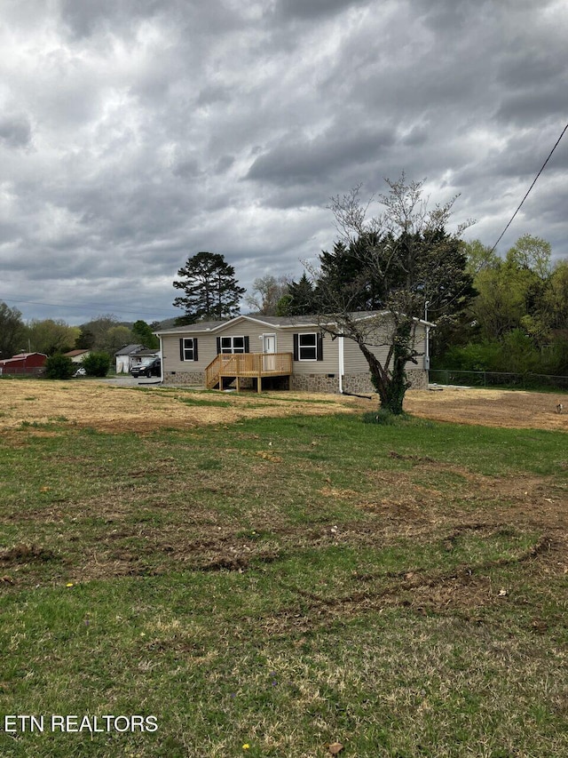 view of front of home featuring a front lawn and a wooden deck