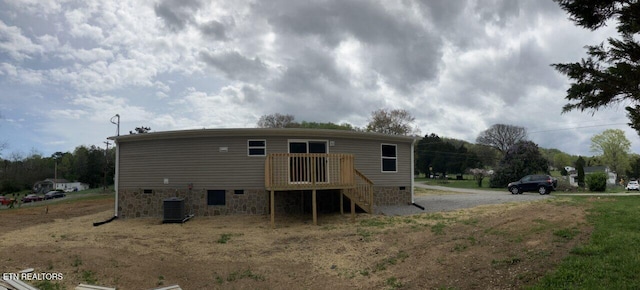back of property featuring stairs, driveway, a deck, central AC unit, and crawl space