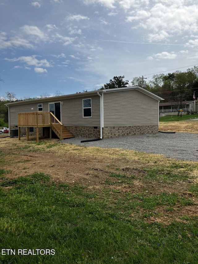 exterior space featuring driveway, a wooden deck, and crawl space