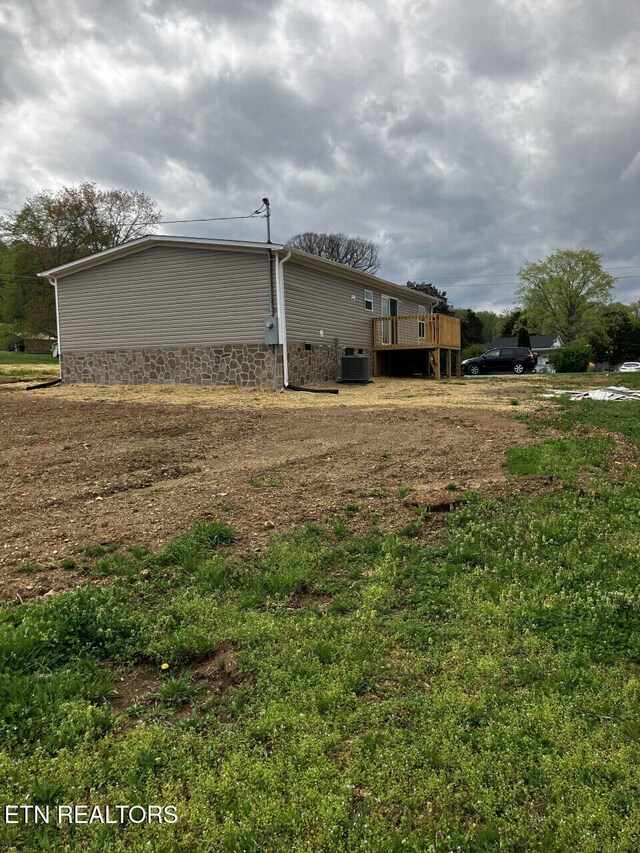 view of side of property featuring central AC unit, a wooden deck, and crawl space