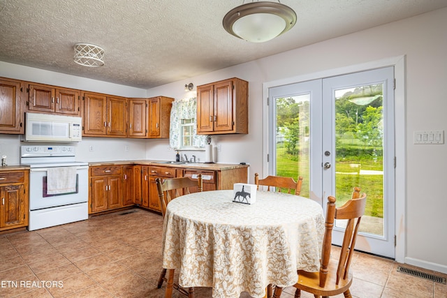 709 Head Of Creek Rd, Sweetwater, TN 37874 - kitchen with white appliances, french doors, brown cabinets, light countertops, and light tile patterned floors