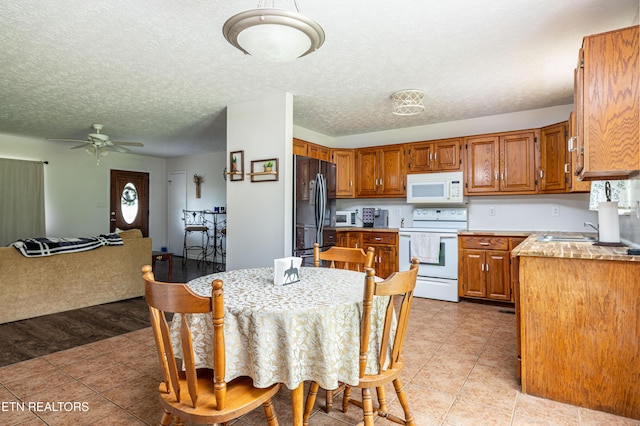 709 Head Of Creek Rd, Sweetwater, TN 37874 - kitchen with white appliances, brown cabinets, light tile patterned floors, light countertops, and a ceiling fan