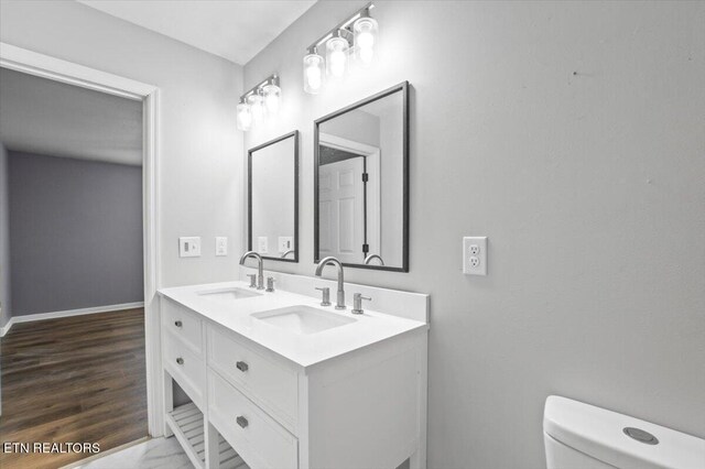 174 Sandy Hill Rd, Lafollette, TN 37766 - bathroom featuring double vanity, toilet, baseboards, and a sink