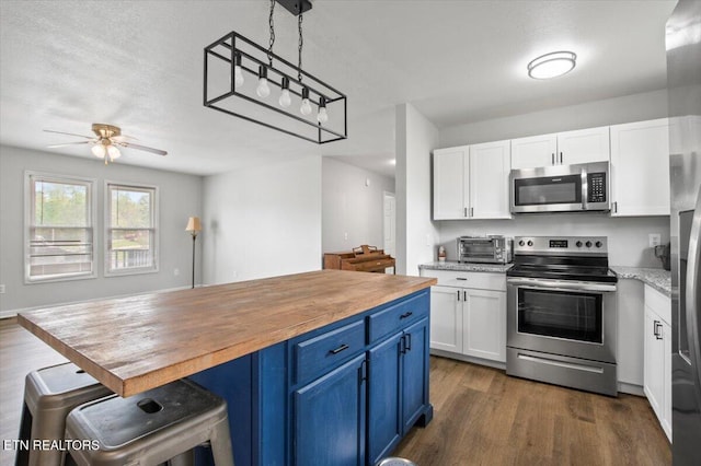 174 Sandy Hill Rd, Lafollette, TN 37766 - kitchen with butcher block countertops, white cabinets, appliances with stainless steel finishes, and blue cabinetry
