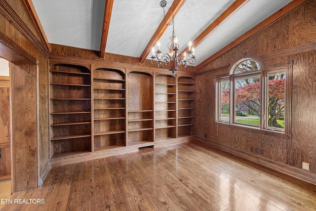 212 Douglas Ave, Sweetwater, TN 37874 - empty room featuring wooden walls, vaulted ceiling with beams, a notable chandelier, and wood finished floors