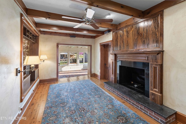 212 Douglas Ave, Sweetwater, TN 37874 - unfurnished living room featuring ceiling fan, light wood-style flooring, a large fireplace, baseboards, and beam ceiling