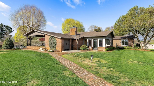 212 Douglas Ave, Sweetwater, TN 37874 - back of property with a chimney, a yard, a sunroom, and brick siding
