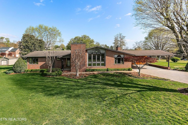 212 Douglas Ave, Sweetwater, TN 37874 - view of front of house featuring a carport, a front yard, brick siding, a chimney, and driveway