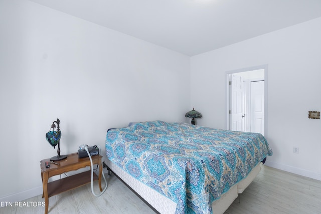 bedroom with light wood-type flooring and baseboards