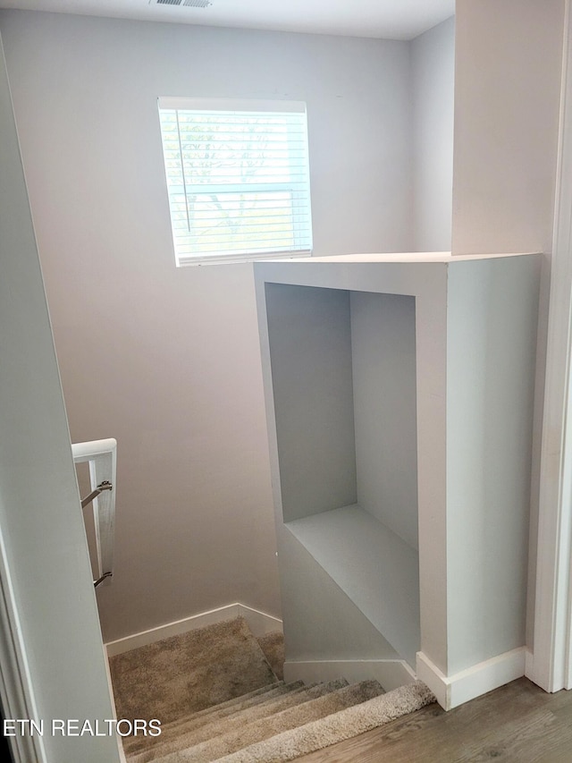 staircase with baseboards and visible vents