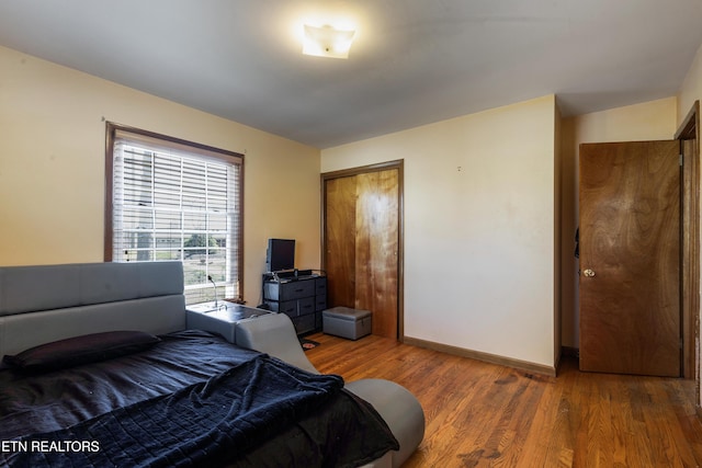 bedroom featuring baseboards, a closet, and wood finished floors