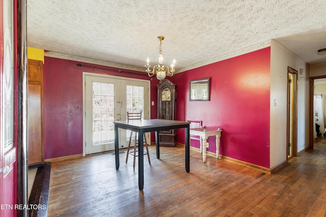 dining area featuring french doors, baseboards, a chandelier, a textured ceiling, and wood finished floors